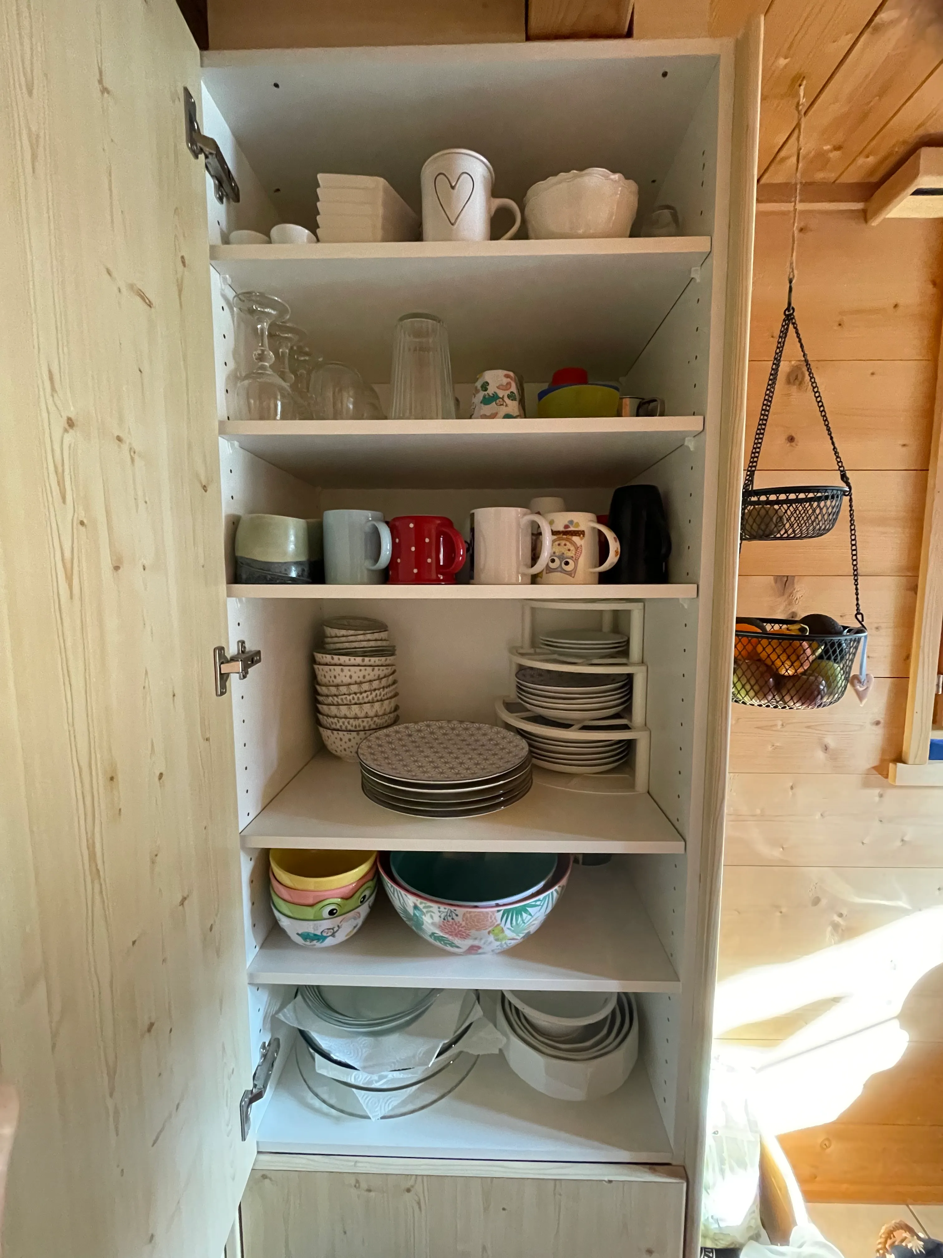 Offener Geschirrschrank, Fächer aufgeräumt.